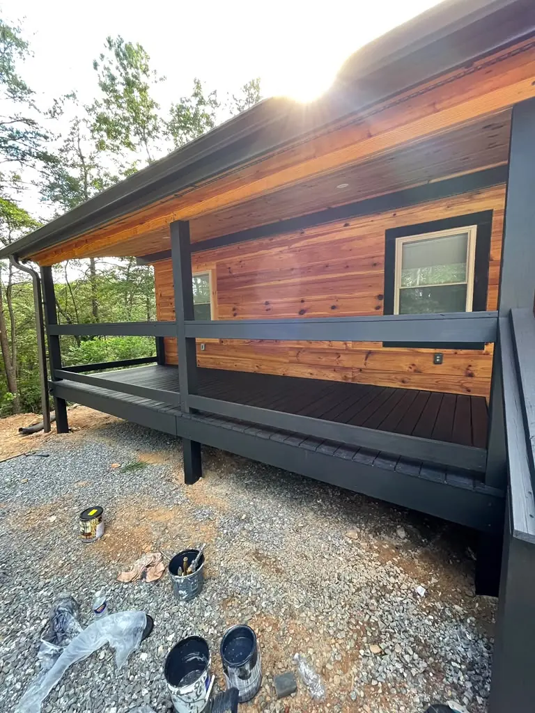Cabin exterior with dark finished porch deck and railings