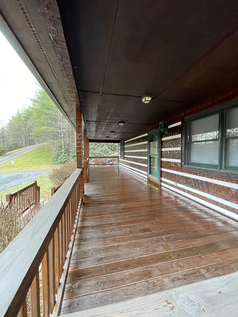 Covered porch with long wood walkway and railing